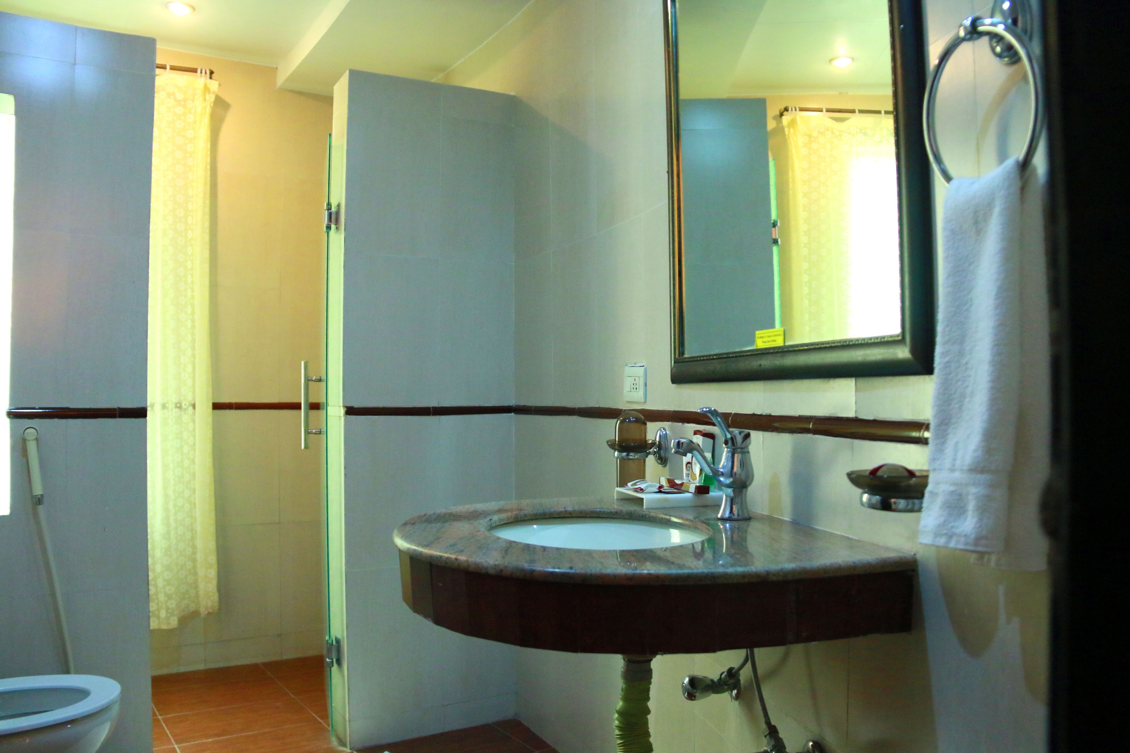 Un baño con lavamanos, espejo e inodoro.