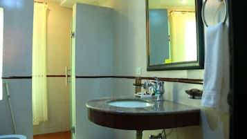 Un baño con lavamanos, espejo e inodoro.