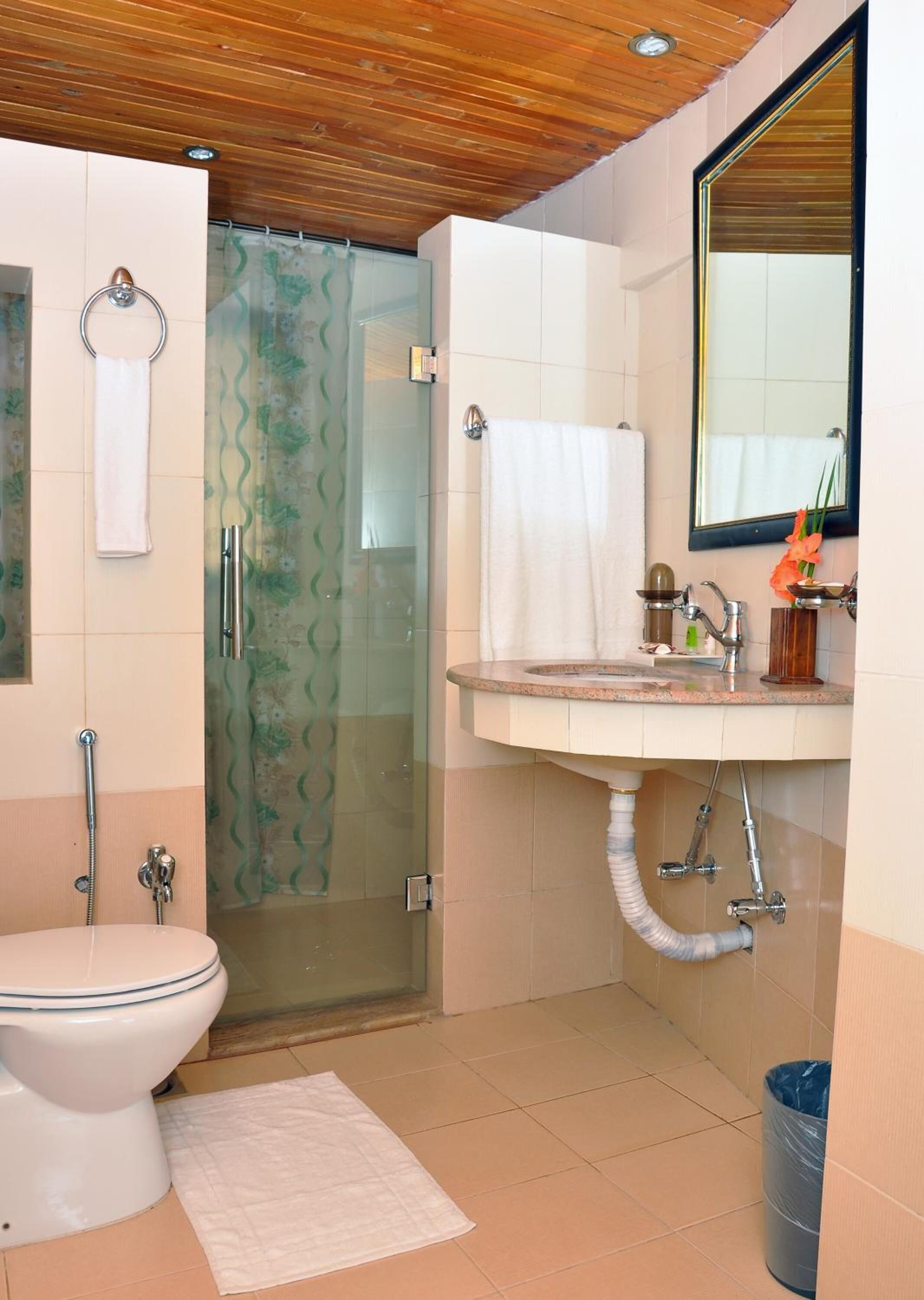 A bathroom with a toilet, shower, and sink.