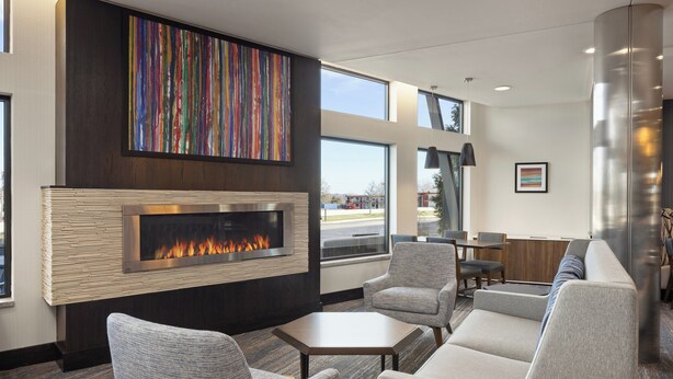 A modern lounge area with a fireplace, comfortable seating, and large windows offering views.