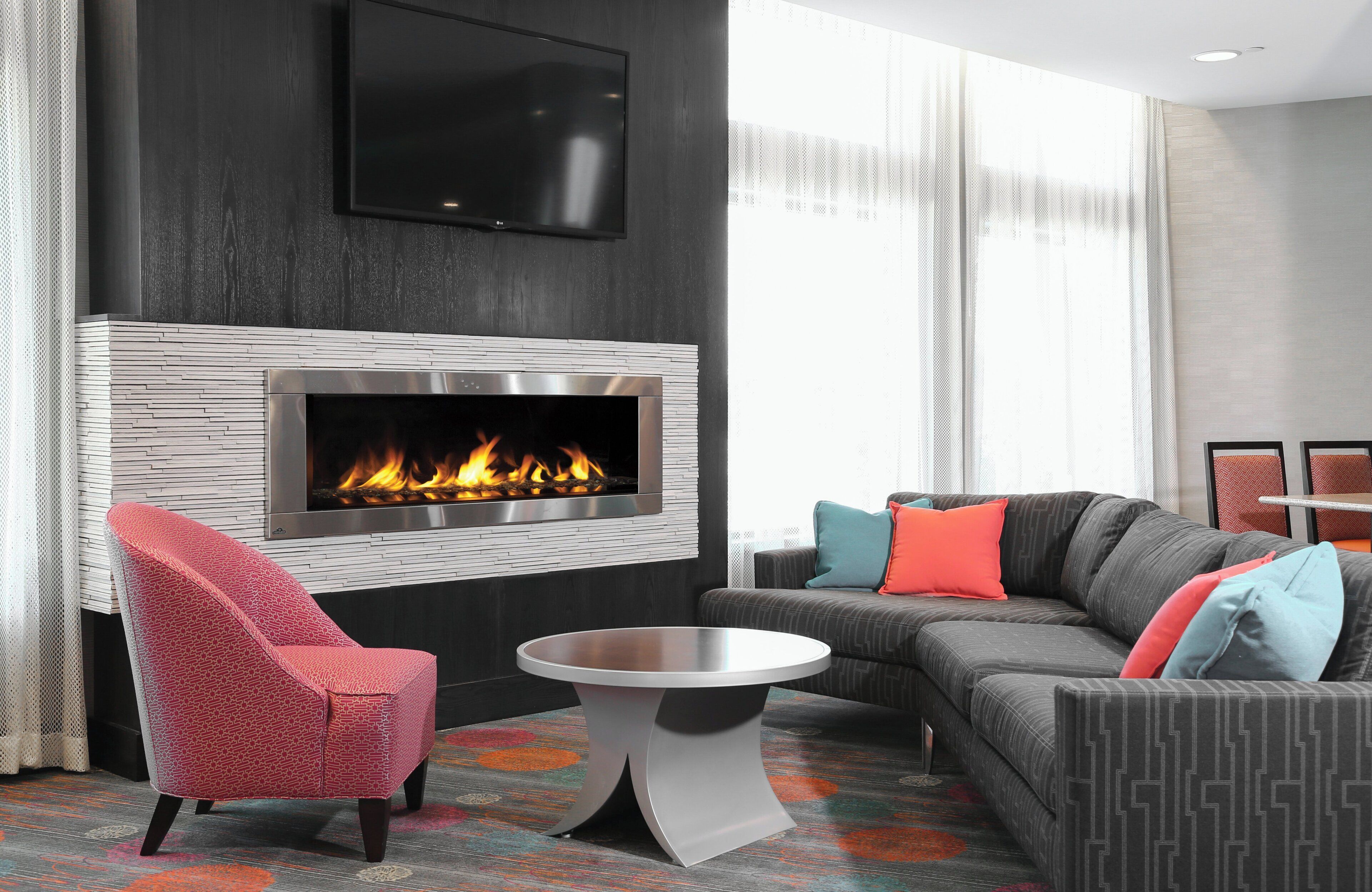 A modern living room with a fireplace, a sofa, a chair, and a coffee table.