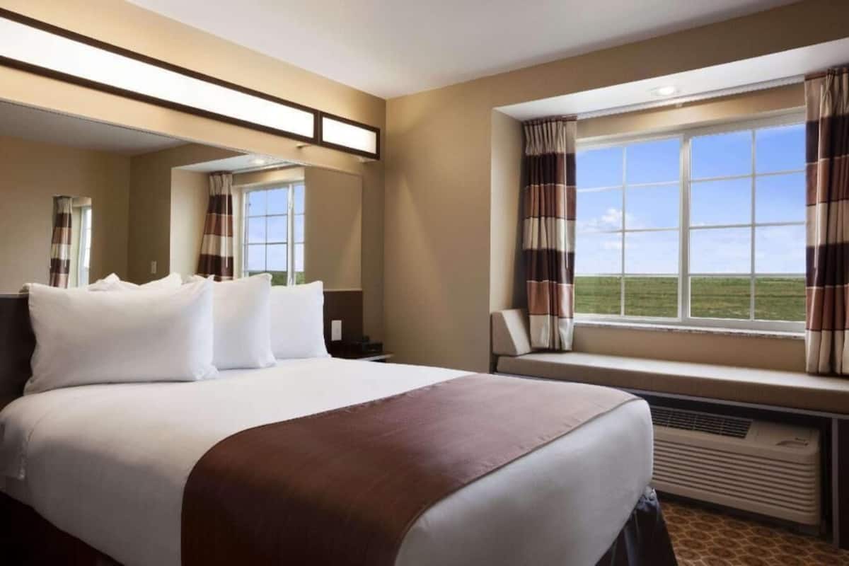 Escritorio, cortinas blackout y tabla de planchar con plancha