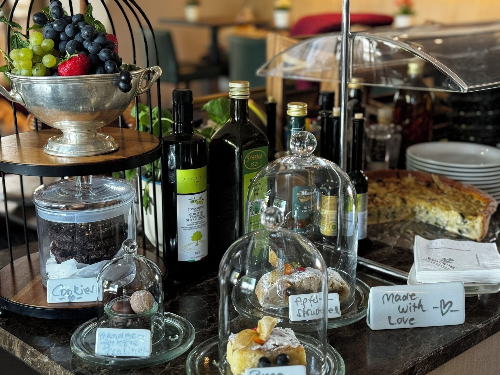 A dessert display with various sweets and a wine selection.