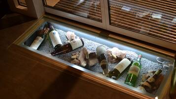 Una vitrina con varias botellas de vino y champán, algunas con corchos, sobre una cama de hielo.