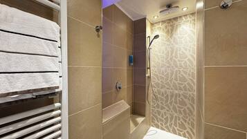 A modern bathroom with a shower, a bathtub, and a towel rack.