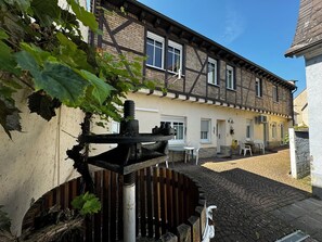 A traditional half-timbered house with a courtyard, a gate, and a small outdoor seating area. - Rhein-Hotel Nierstein (Nierstein)