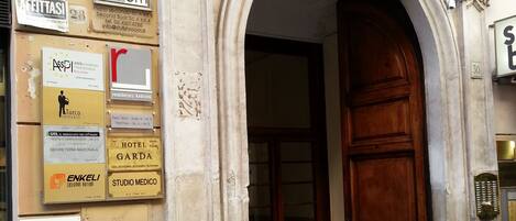 Una entrada de edificio con una puerta de madera grande y un arco de piedra ornamentado.