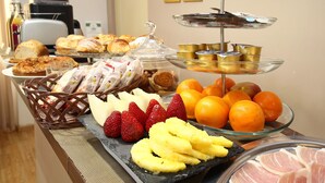 A buffet with various food items including pastries, fruits, and meats. - DG Prestige Room (Rome)
