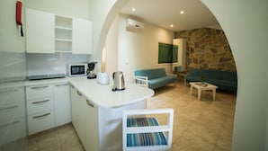 A compact living space with a kitchen, a dining area, and a seating area. - Myroandrou Beach Apartments (Paralimni)