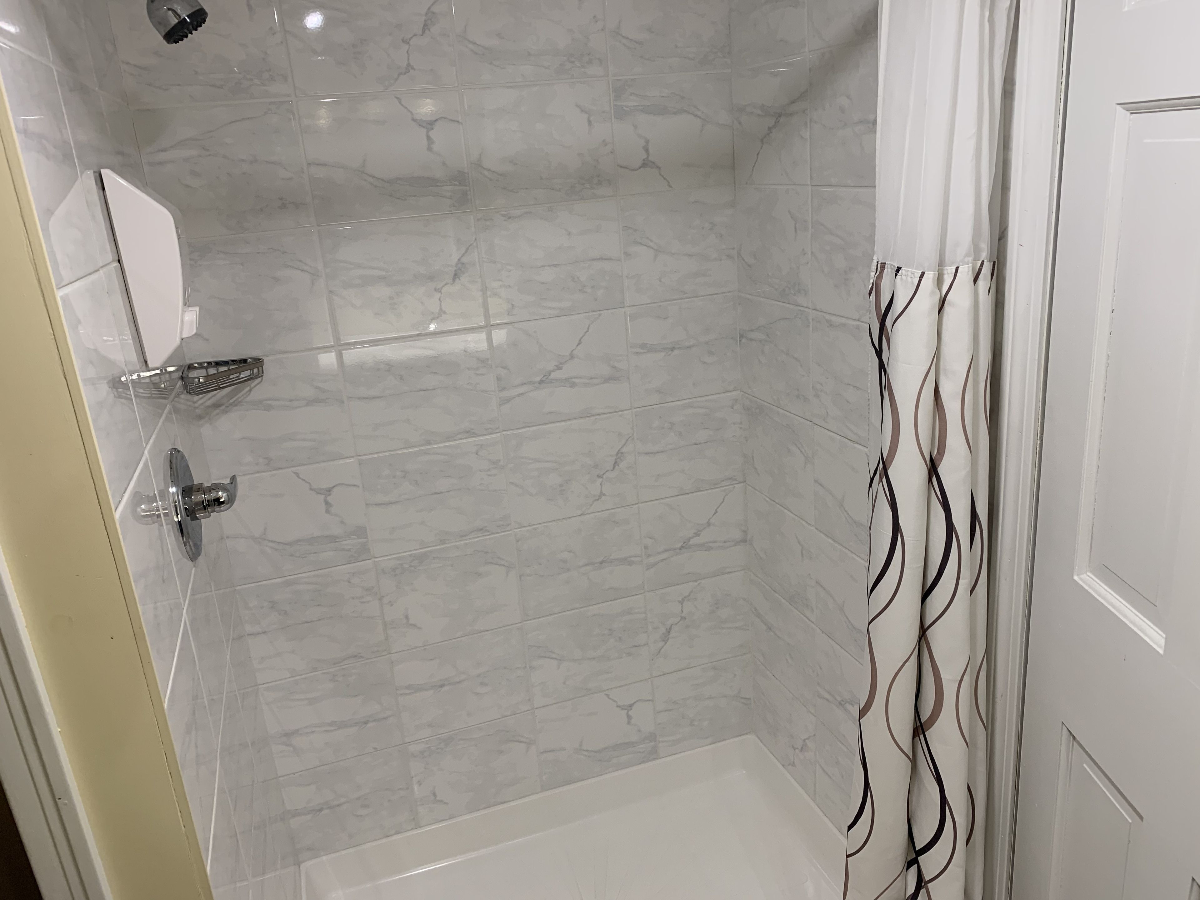 A modern bathroom with a shower, a toilet, and a sink.
