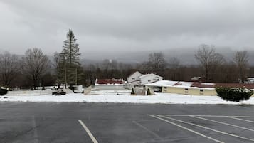 Un estacionamiento con nieve en el suelo y un edificio al fondo.