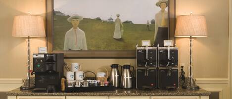 Un comptoir de cuisine avec des machines à café, un tableau encadré et un espace dédié au café.