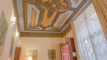 Une pièce dotée d’un plafond décoratif, d’un téléviseur à écran plat et d’une porte en bois.