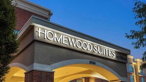A hotel entrance with the name "HOMEWOOD SUITES by Hilton" and the address "2036".