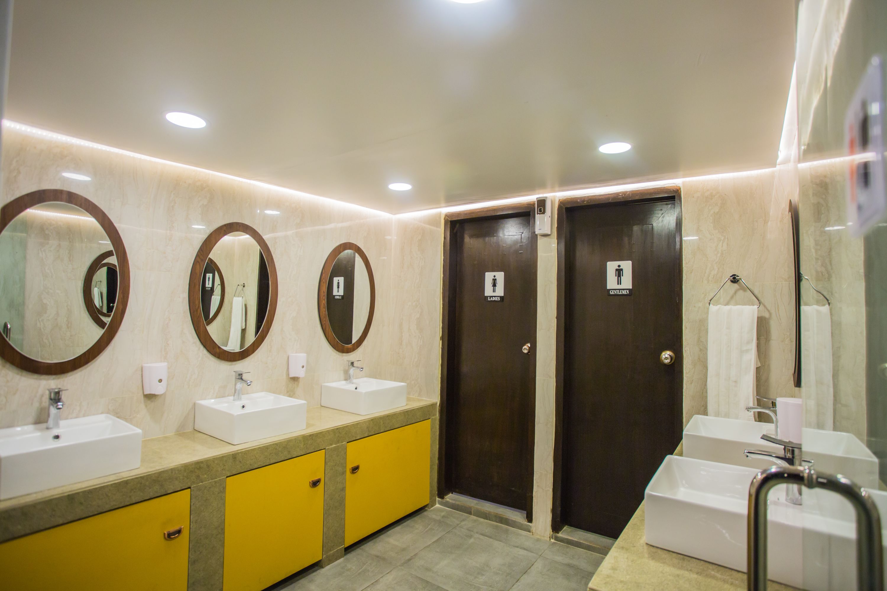 A modern bathroom with two sinks, mirrors, and a towel rack.