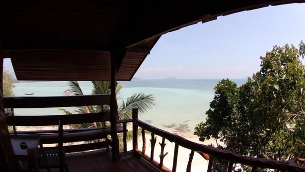 A wooden deck with a view of a beach and ocean. - Moon Beach Resort (Ko Pha-ngan)