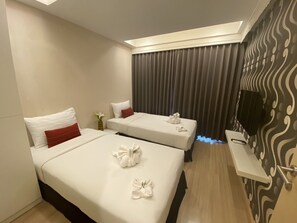A hotel room with two beds, a flat-screen TV, and a small table. - De Richy Chiang Mai (Hang Dong)