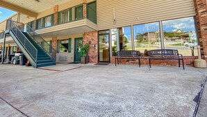 A building with a covered entrance, a staircase, and a bench outside. - Green Gables Inn (Branson)