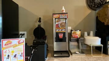 Un espace en libre-service où l’on peut préparer des gaufres, avec un distributeur de sirop et un bouton-poussoir pour lancer la cuisson des gaufres.