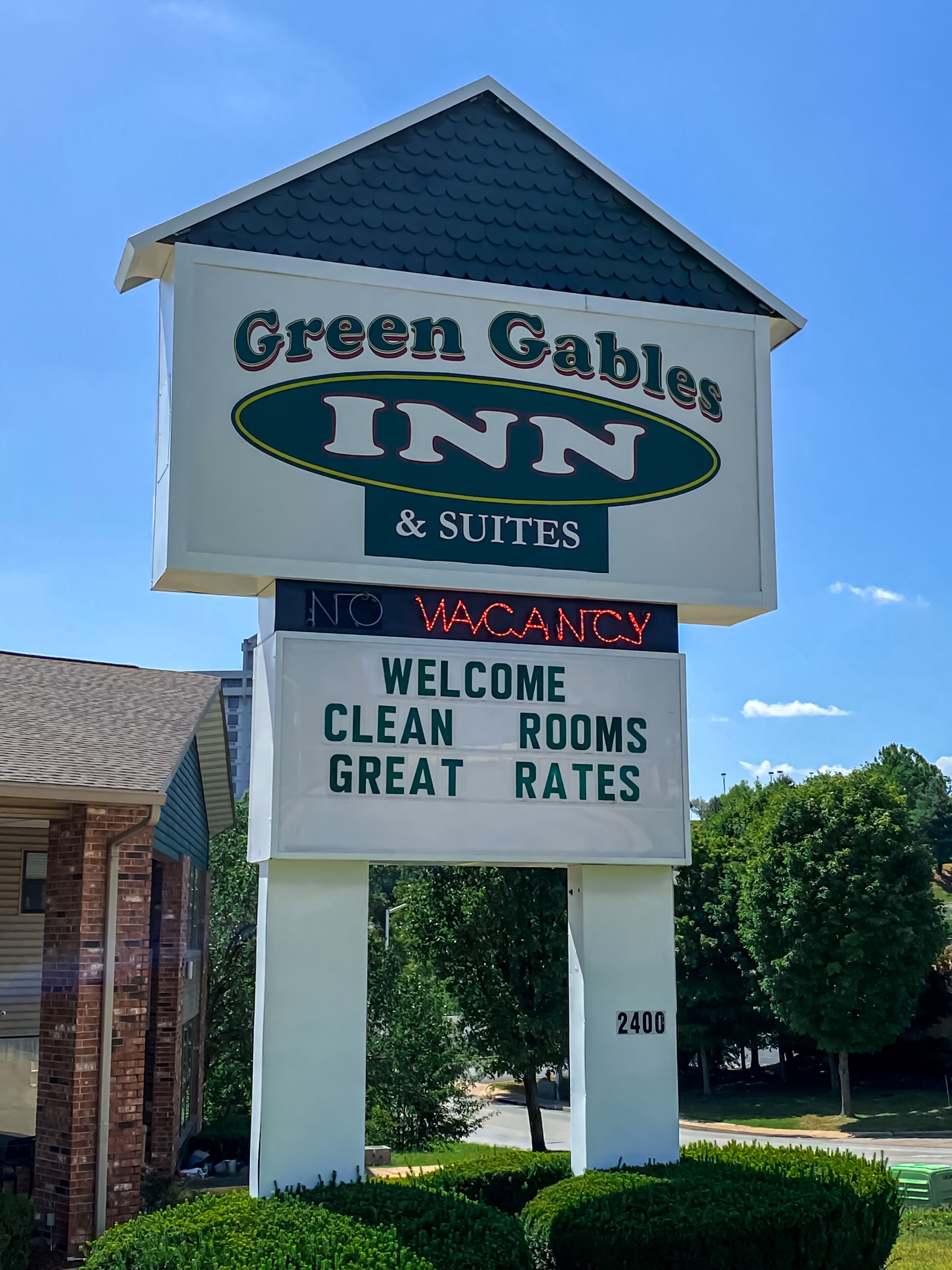 A hotel sign with the name "Green Gables Inn & Suites" and a message stating "NO VACANCY" and "WELCOME CLEAN ROOMS GREAT RATES".