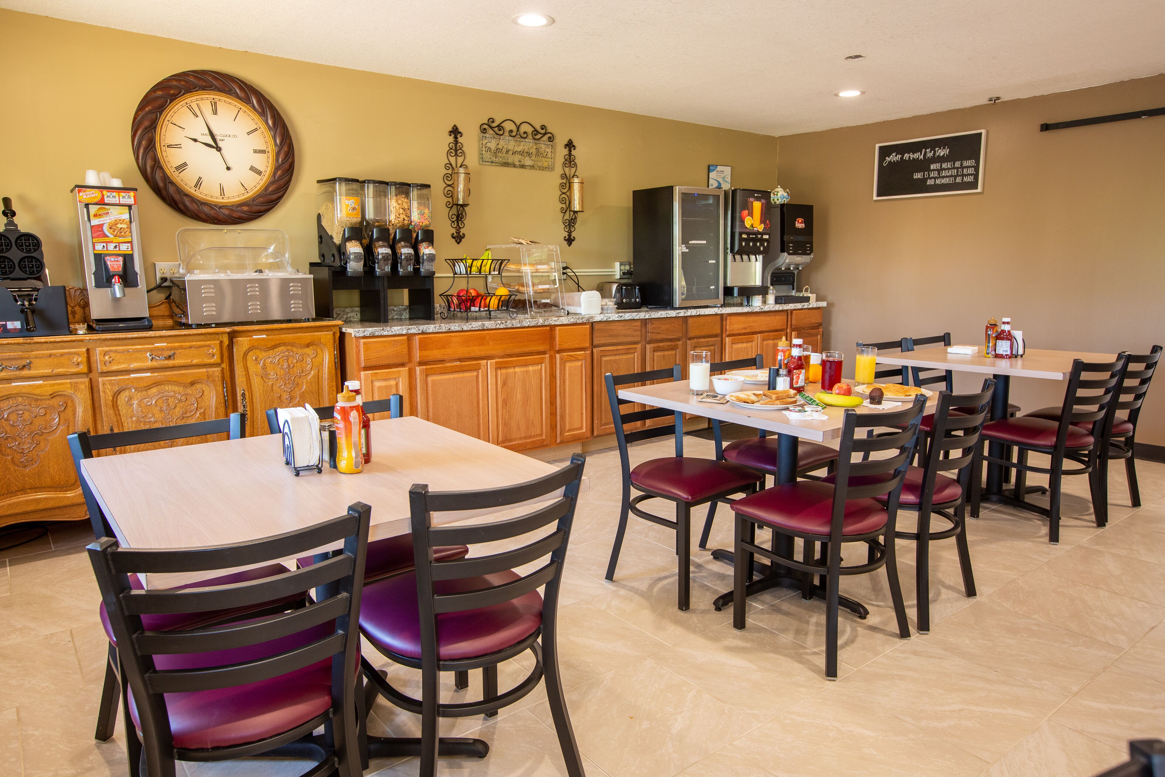 A restaurant with wooden cabinets, a coffee machine, and a clock on the wall.