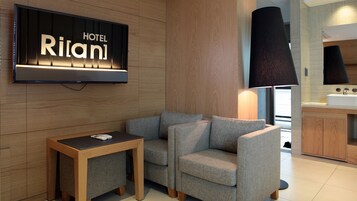 Un moderno vestíbulo de hotel con un televisor de pantalla plana mostrando
