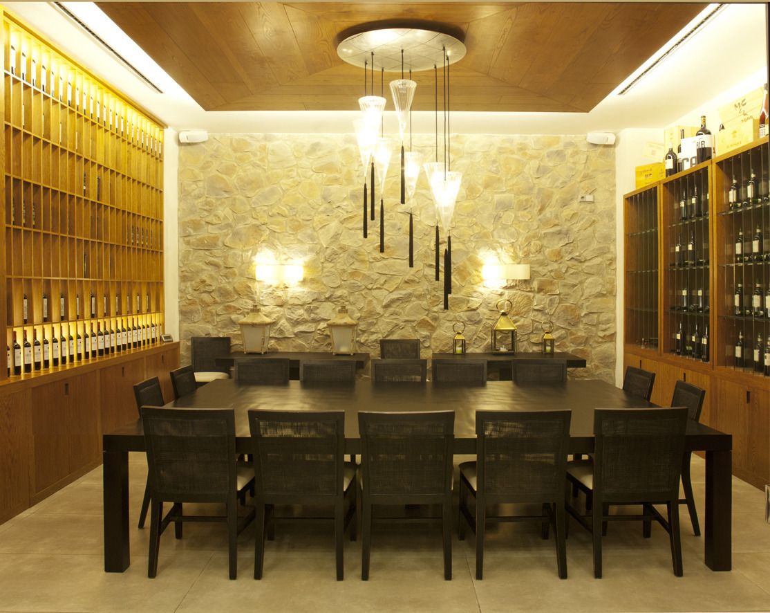 Zona pranzo con parete in pietra, rivestimenti in legno e una dispensa per vini.