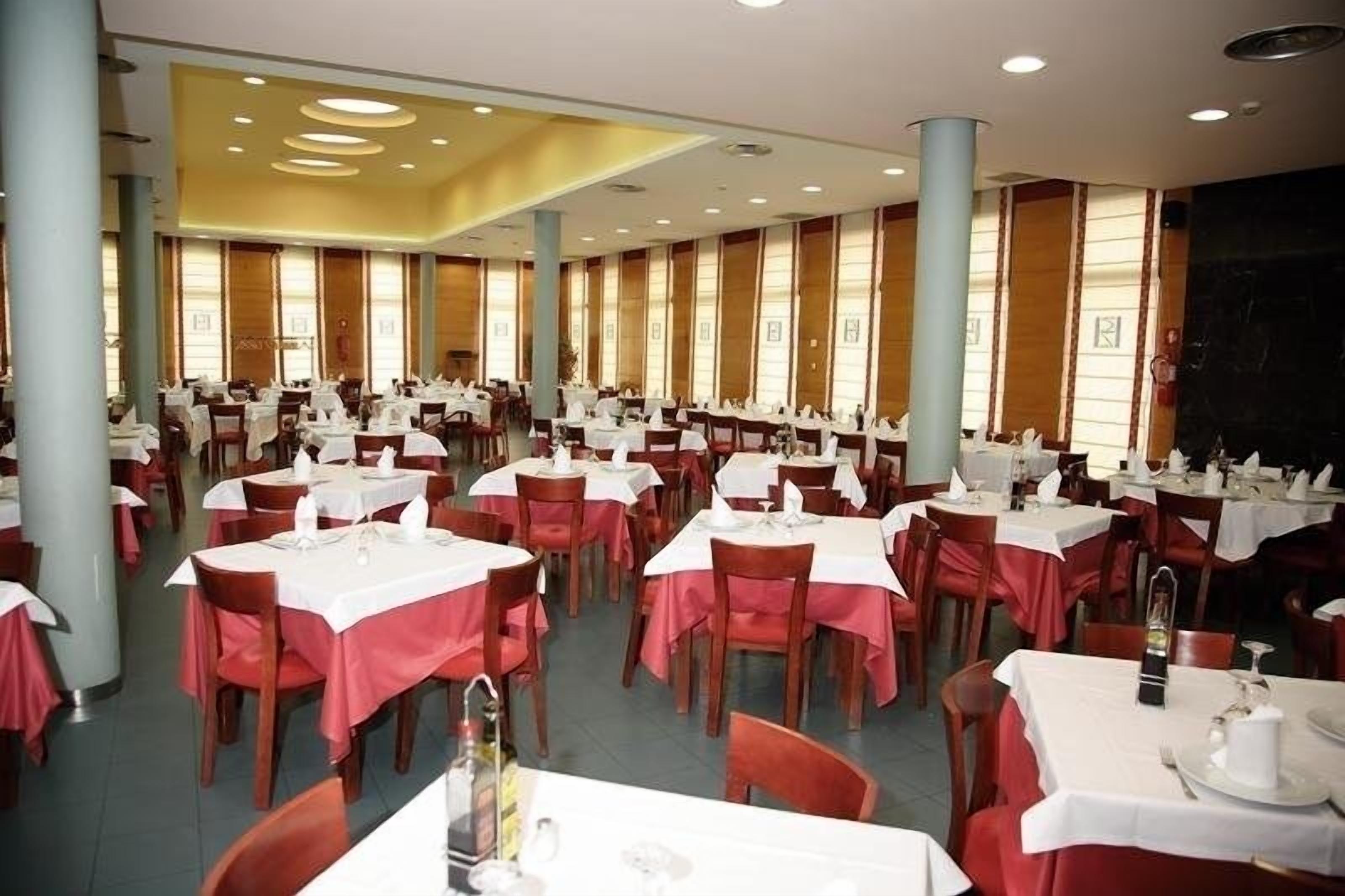 Un amplio comedor con múltiples mesas y sillas, dispuestas en filas.