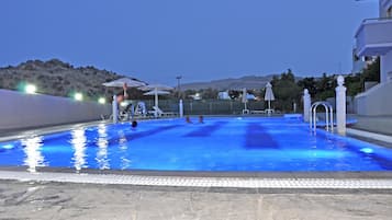 Piscine extérieure, parasols de plage, chaises longues