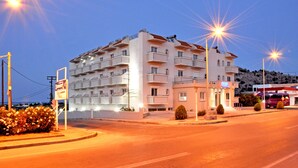 A multi-story hotel with balconies, a signboard, and a parking area. - Daniel Luxury Apartments (Rhodes)