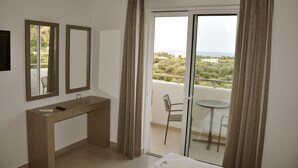 A hotel room with a balcony, a desk, and a bed. - Daniel Luxury Apartments (Rhodes)
