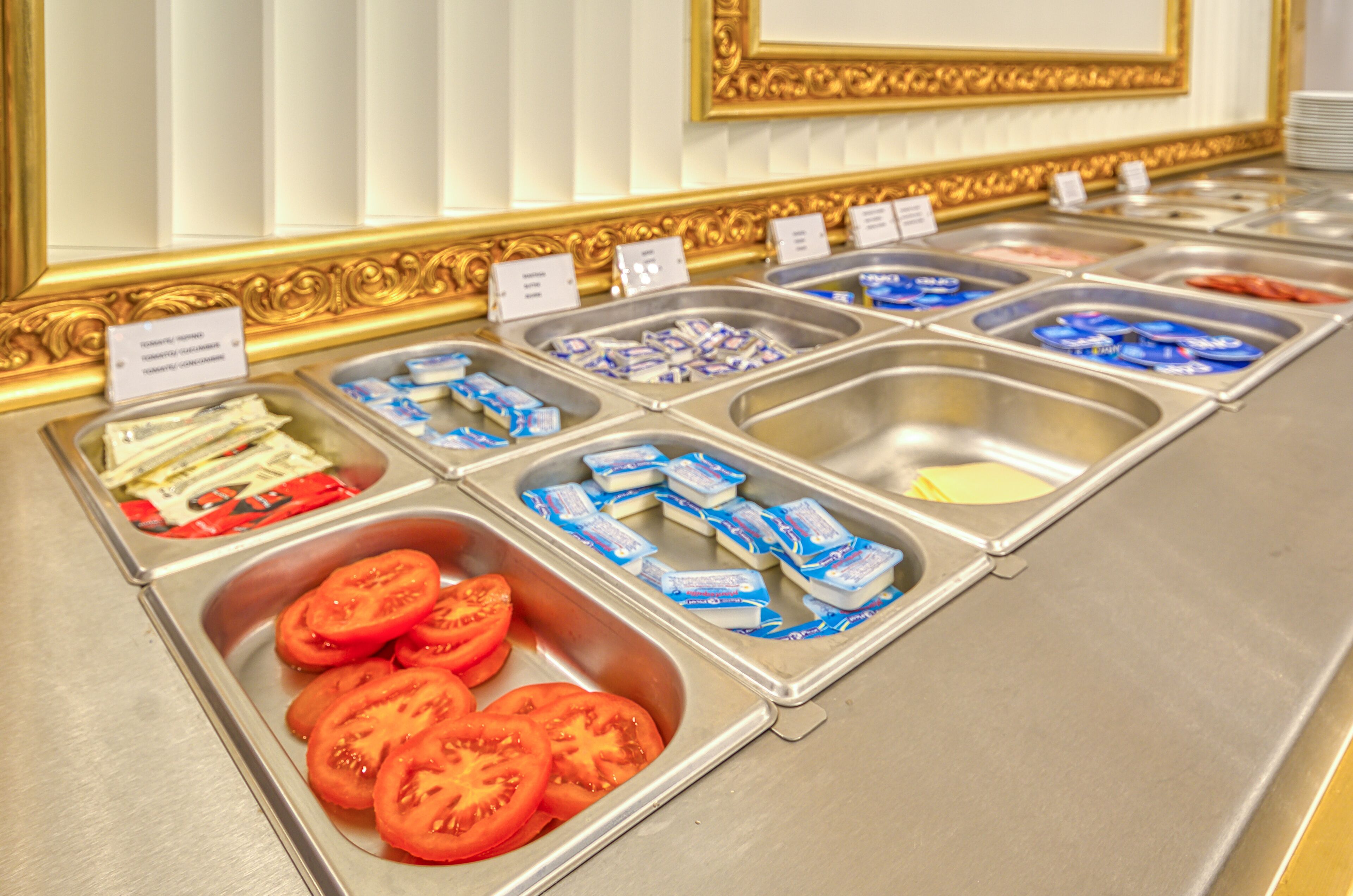 Un buffet proposant une variété d’aliments, notamment des tomates en tranches, du fromage et d’autres plats préparés.