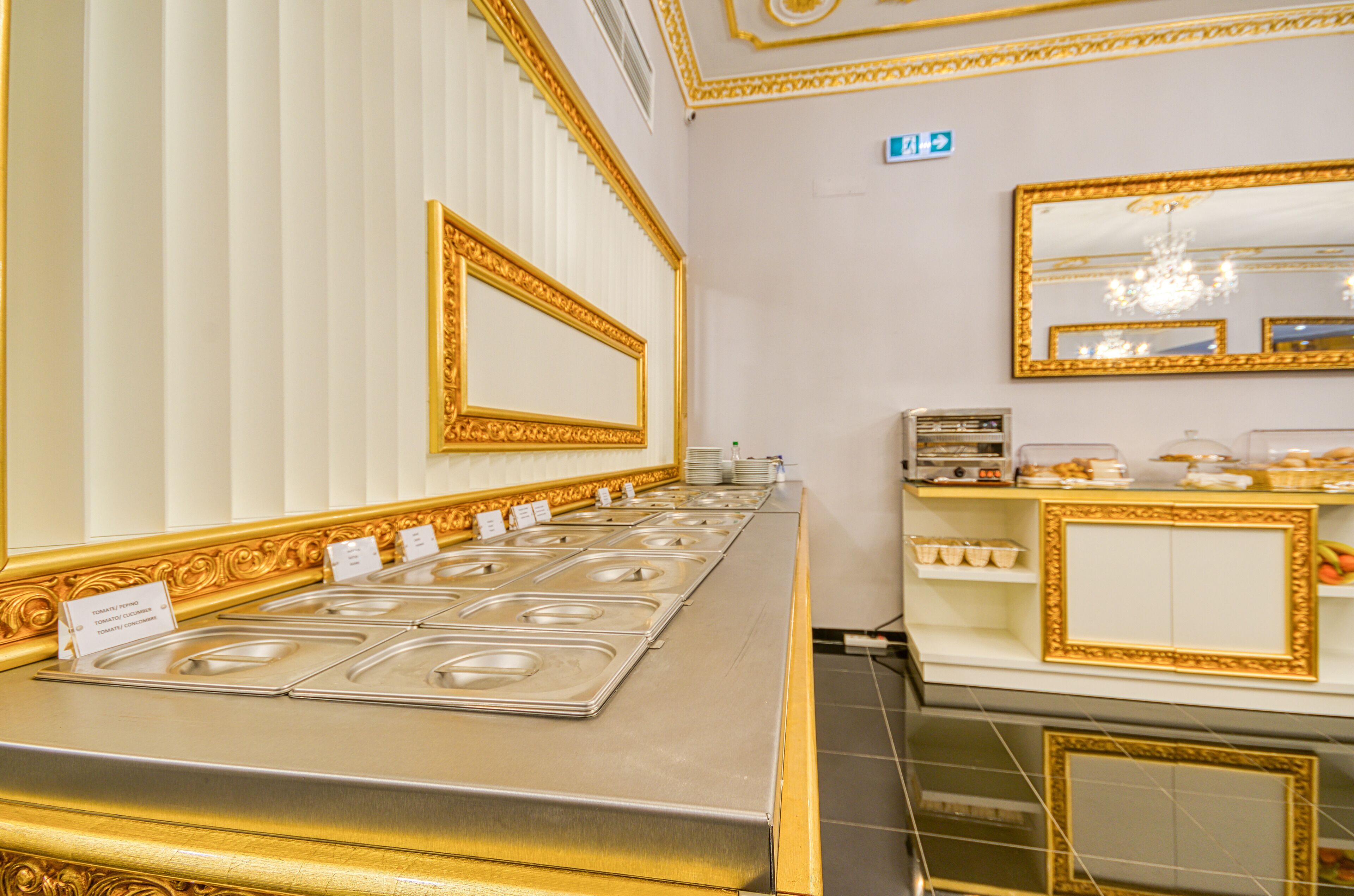Un área de buffet con varias estaciones de servicio, un espejo y una pequeña kitchenette.
