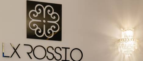 A wall with a logo and the name "LX ROSSIO" in a modern font.