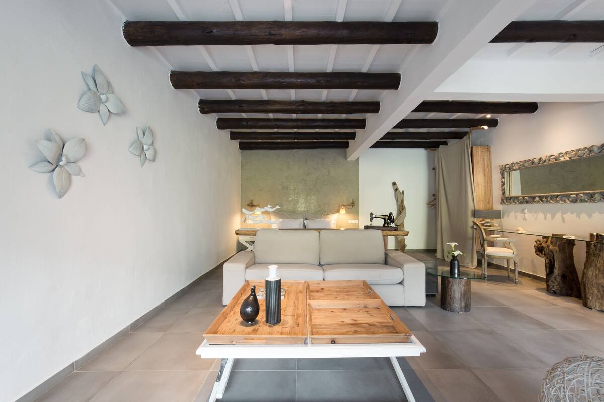 Een moderne woonkamer met een houten salontafel, een bank en decoratieve wandkunst.