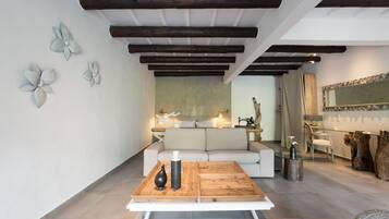 Una sala moderna con una mesa de centro de madera, un sofá y decoración en la pared.