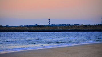 A beach with a lighthouse in the distance.