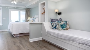 A bedroom with two beds, a ceiling fan, a walk-in closet, and a view through a window.