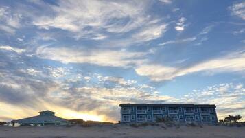 A beachfront building with multiple balconies and a beachside structure.