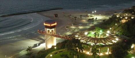 A coastal resort with a beach, a central pavilion, and a viewing tower.