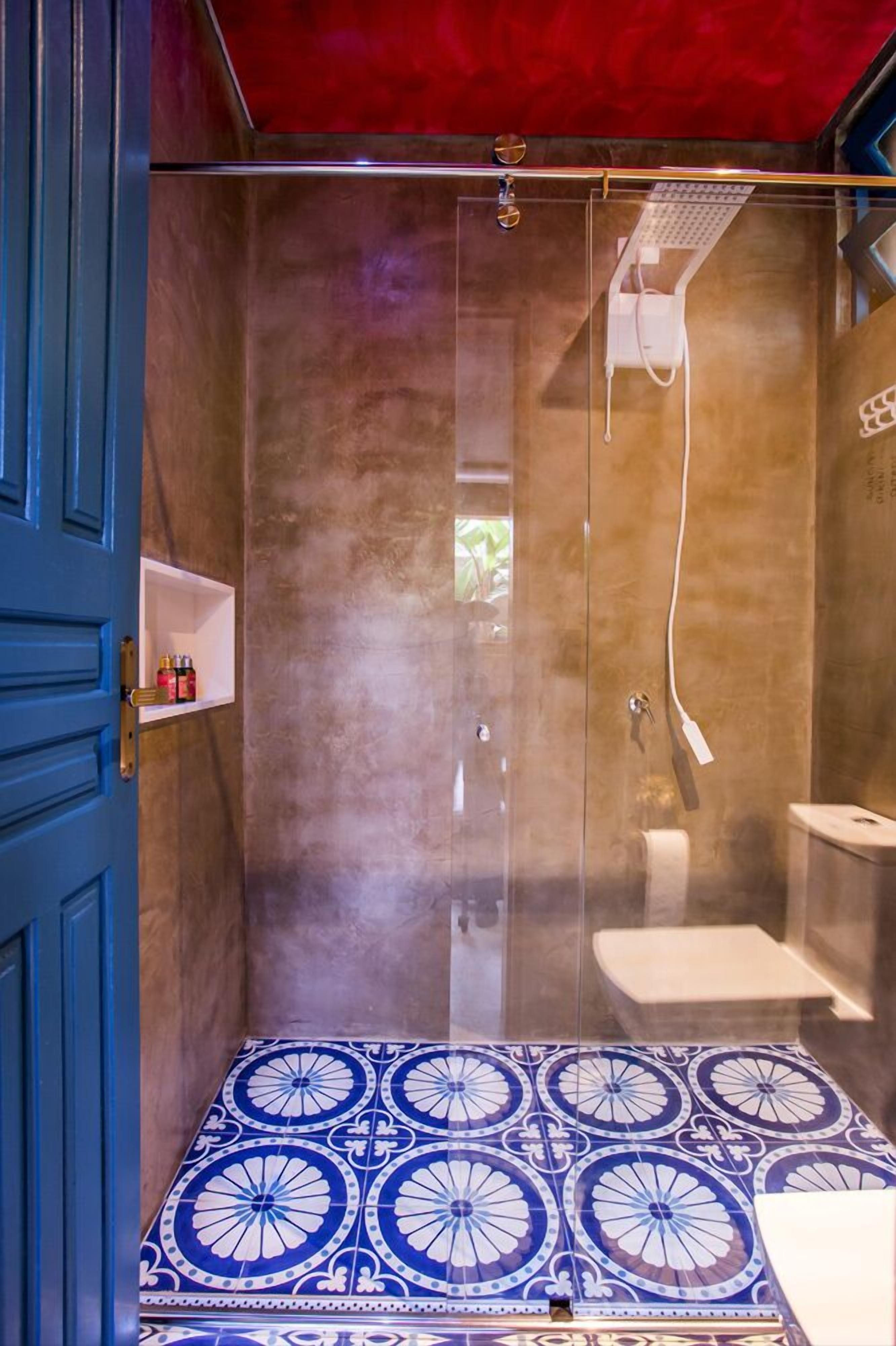 Une salle de bain avec une douche, des toilettes et une étagère contenant des articles de toilette.