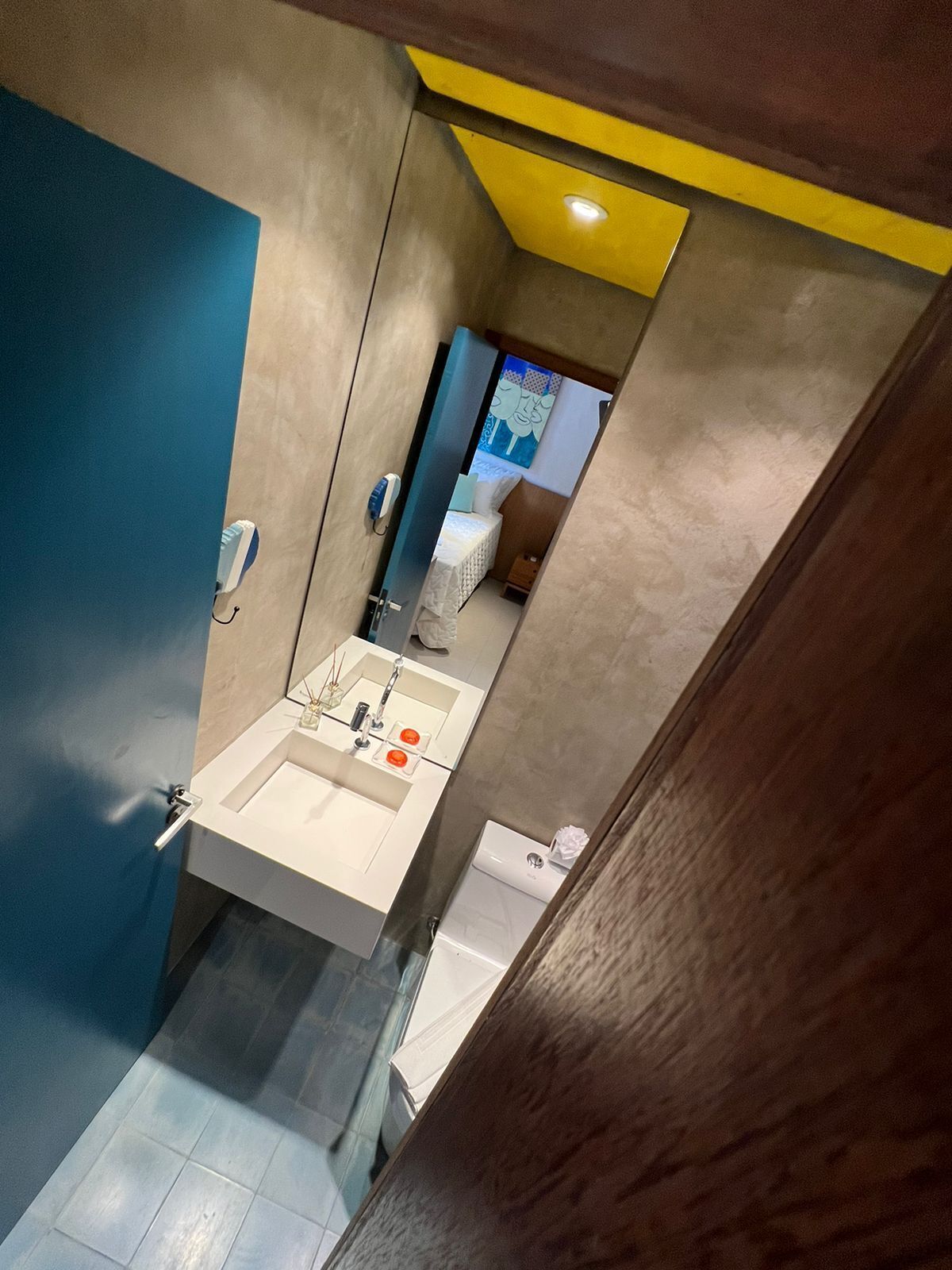 Un baño moderno con lavamanos, espejo y retrete.