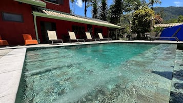 Alberca al aire libre, sombrillas en la alberca y camastros