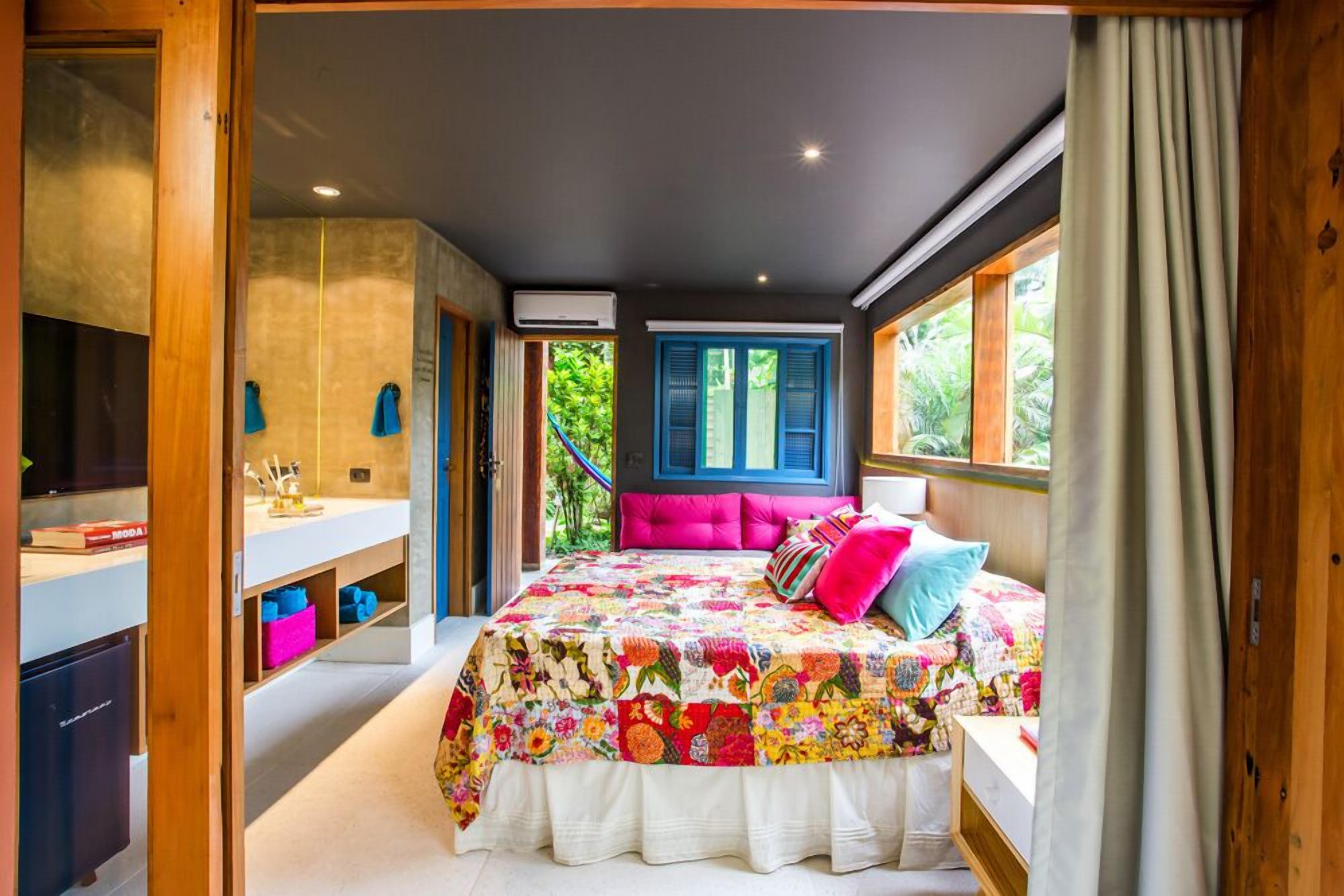 Una camera da letto con un letto grande, un armadio in legno, una toeletta e una finestra con persiane blu.
