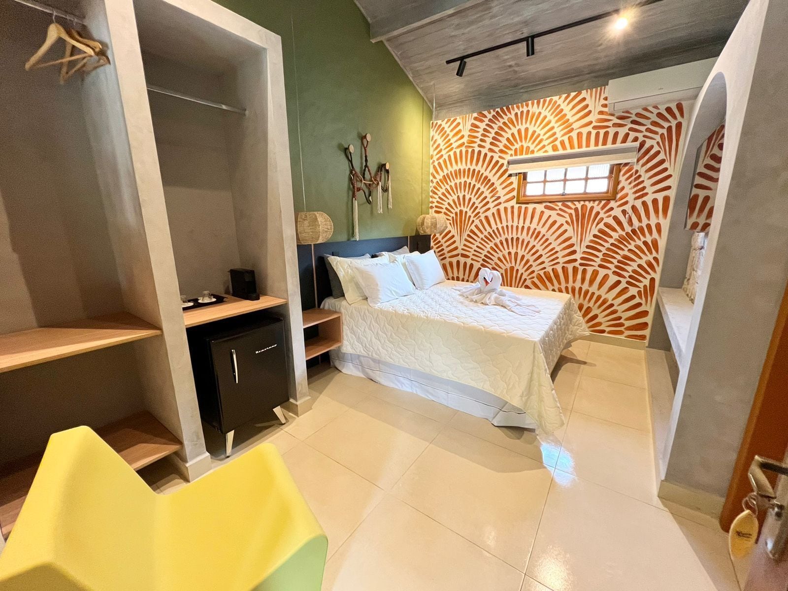 A modern bedroom with a bed, a desk, a chair, and a wardrobe.