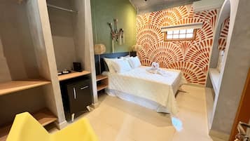 A modern bedroom with a bed, a desk, a chair, and a wardrobe.