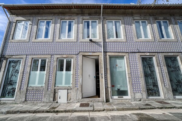 A building with a tiled facade, multiple windows, and a door. - Olala Fine Arts Studios (Porto)