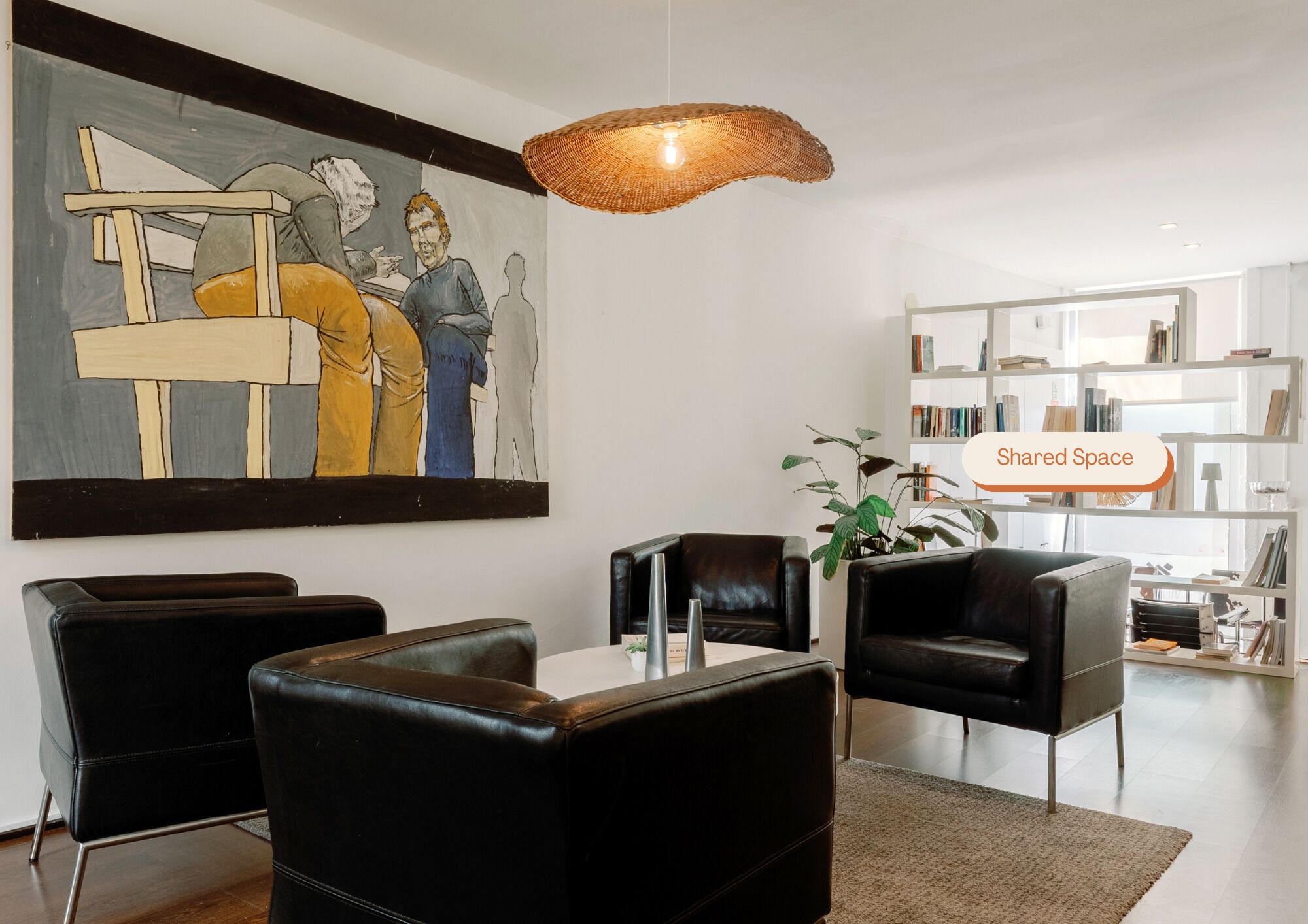 A modern living room with a large abstract painting, leather furniture, a woven light fixture, and a bookshelf.