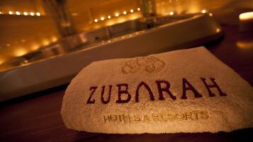 Uma toalha com a inscrição bordada 'ZUBARAH HOTELS & RESORTS'.