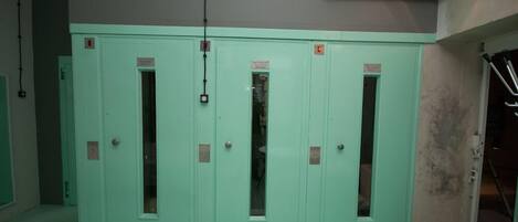 Un ensemble de portes d’ascenseur vertes, avec un panneau de commande situé au-dessus.